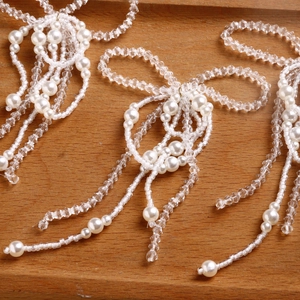 Detail of handmade bow-shaped pearl beaded ornament with tassel for DIY hair accessories
