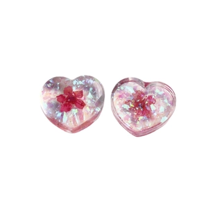 Translucent heart-shaped resin charms with embedded dried flowers and colorful sequins