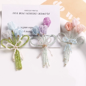 Vue détaillée des broches tulipes faites à la main en perles de couleurs bleu, violet et rose