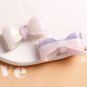 Macro detail of gradient iridescent bow hair clip showing pearlized resin texture