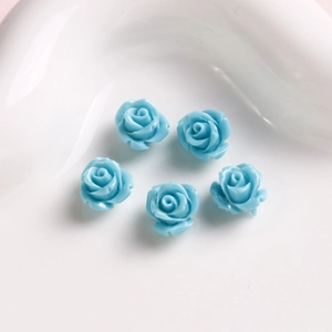 Vista detallada de flores de rosa de resina azul claro para joyas DIY y manicura