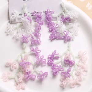 Detailed view of handmade beaded flower tassels in purple and pink for DIY jewelry
