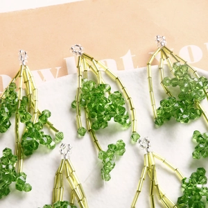 Détail macro d'un accessoire à pampilles en perles avec cristaux verts et tubes jaunes