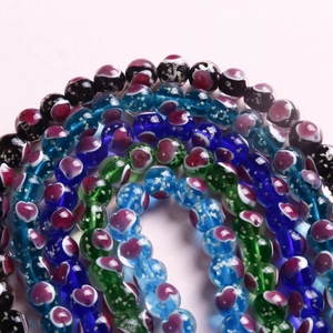Makroaufnahme von 10mm Glasperlen mit roten Herzmustern und Politur für DIY-Schmuck
