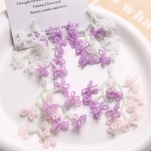 Close-up of handmade beaded floral charms in pink and purple for DIY earring jewelry making