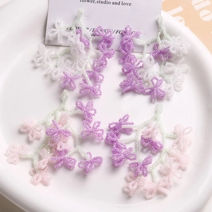 Detailed view of handmade beaded flower tassels in pink and purple for DIY earrings