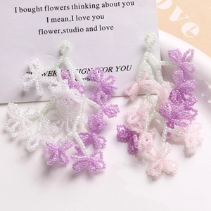 Macro shot of handmade beaded flower tassels in pastel pink and purple tones