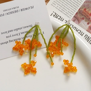 Boucles d'oreilles artisanales en perles orange et tube vert au design floral de printemps