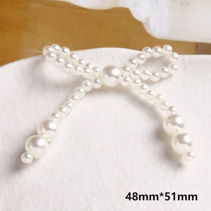 Dettaglio di un accessorio per gioielli a forma di fiocco di perle fatto a mano