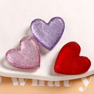 Macro detail of heart resin charms with silver foil flakes for DIY jewelry accessories
