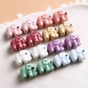 Colorful ceramic elephant beads for DIY jewelry making on a white textured tray
