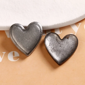 Macro shot of vintage silver heart-shaped metal charms for DIY jewelry accessories