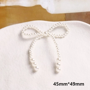Dettaglio di un accessorio a fiocco in perle fatto a mano di misura 45mm per 49mm