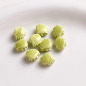 Detail of 12mm fan-shaped shell ceramic beads in light green for DIY jewelry making