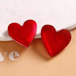 Close-up of red heart resin charms with pearlescent finish and silver foil texture