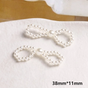 Dettaglio di fiocchi in perle fatti a mano per gioielli fai-da-te, misura 38mm x 11mm