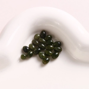 Macro shot of 6mm oval dark green natural stone beads with holes for DIY jewelry