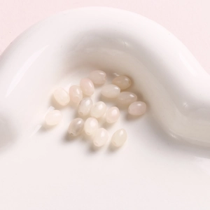 Macro shot of 6mm oval natural stones in light pink and beige for DIY jewelry crafting