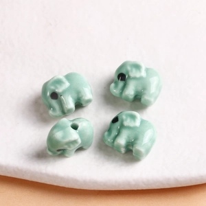 Macro detail of four light green ceramic elephant beads with ice crackle glaze for DIY