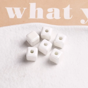 Macro shot of 9mm white glazed cube beads with central holes for DIY jewelry making