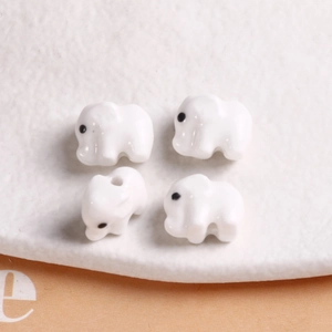 Set of four glossy white ceramic elephant beads for DIY jewelry making and crafts
