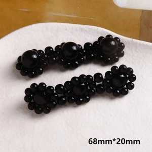 Dettaglio di fermagli per capelli a fiori con perle nere da 68mm su ceramica