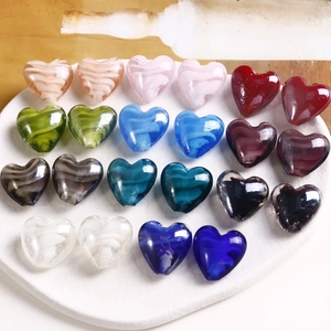 Dettaglio di perline di vetro colorate a forma di cuore con venature per bijoux fai-da-te