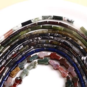 Macro shot of natural stone column beads and cross pendants in lapis and agate textures