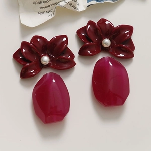Detail of red resin flower earrings with pearls and translucent pink stone charms
