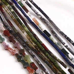 Macro shot of natural stone column beads and cross pendants in lapis and agate