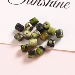Macro view of 6mm cylindrical natural green stone beads with unique marbled patterns