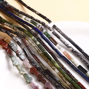 Macro shot of assorted natural stone beads including cross shapes for DIY jewelry making