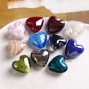 Perline di vetro a forma di cuore marmorizzato con colori vivaci su vassoio bianco