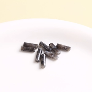 Macro shot of cylindrical natural stone beads with black and white marble texture for DIY