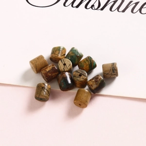 Detail of 6mm cylindrical natural ocean jasper beads with multicolored mineral texture