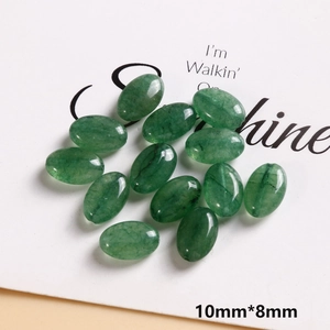 Detailed view of 10mm oval green natural stone beads with smooth polished surface