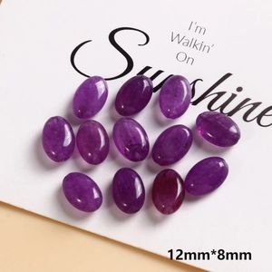 Macro detail of 12mm x 8mm purple oval natural stone beads with smooth polished finish