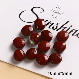 Detailed macro view of 10x9mm red jasper flat oval natural stone beads for DIY jewelry