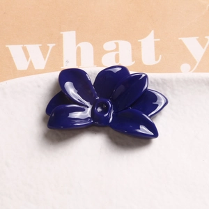 Close-up of a blue resin flower accessory with a glossy finish and a five-petal design