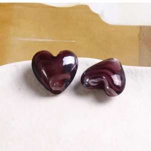 Dettaglio di perle in vetro a forma di cuore con effetto marmorizzato viola scuro