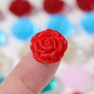 Vue macro d'une rose en résine rouge sur un doigt pour référence de taille DIY