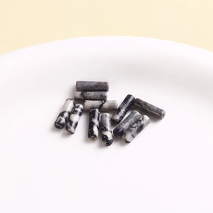 Detailed macro shot of cylindrical marble stone beads with natural black and white veins