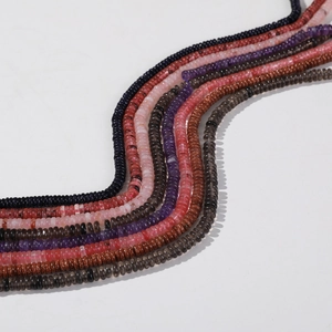 Macro detail of multicolored 6mm rondelle gemstone beads arranged in elegant S-curves
