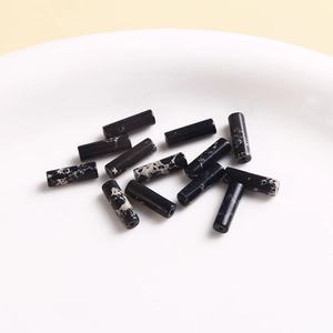 Macro shot of natural marble style cylindrical beads with black and white vein textures