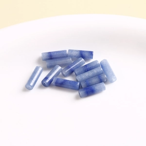 Close-up of blue natural stone cylinder beads on white tray for DIY jewelry making