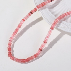 Macro detail of 6mm pink natural strawberry quartz disc beads on ceramic plate