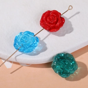 Perles roses en résine DIY rouges, bleues et vertes pour bijoux sur assiette blanche