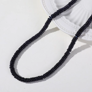 Macro detail of 6mm blue goldstone flat round spacer beads with starry glitter effect