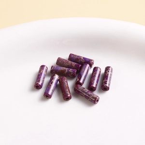 Macro view of cylindrical purple stone beads with crackle texture for jewelry making