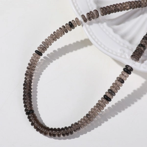 Macro detail of 6mm smoky quartz flat beads and black spacers for jewelry making